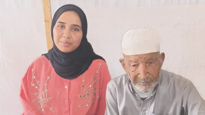 Rahaf Abu Khatla sitting beside her father, Jumaa Abu Khatla.